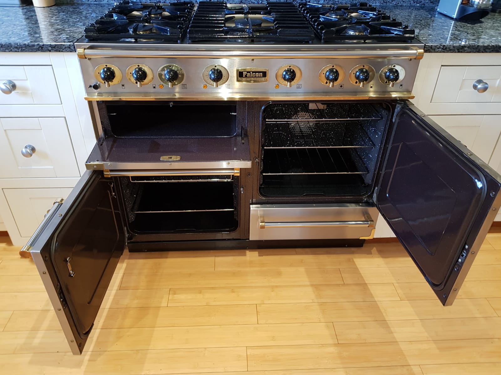 Stainless range cooker with two lower doors open showing clean interiors
