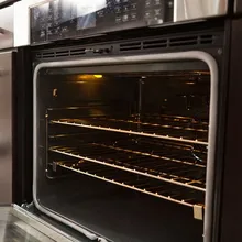 Clean oven interior with the door open and racks polished